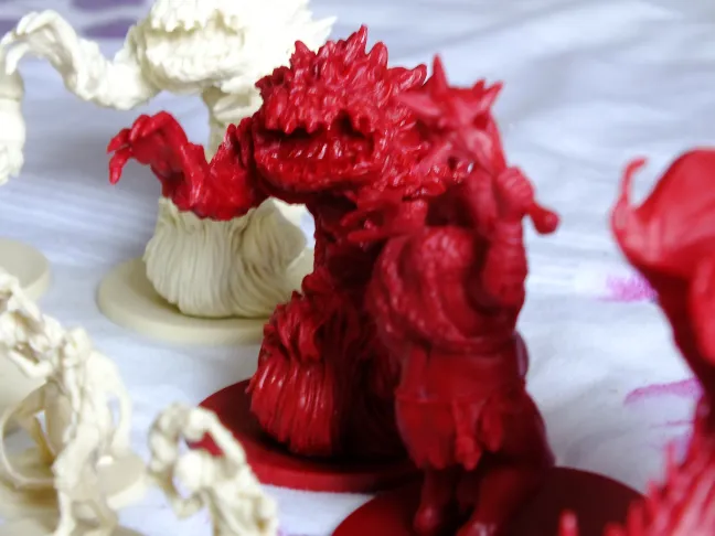 Close-up of a red Overlord monster miniature with detailed scales and claws
